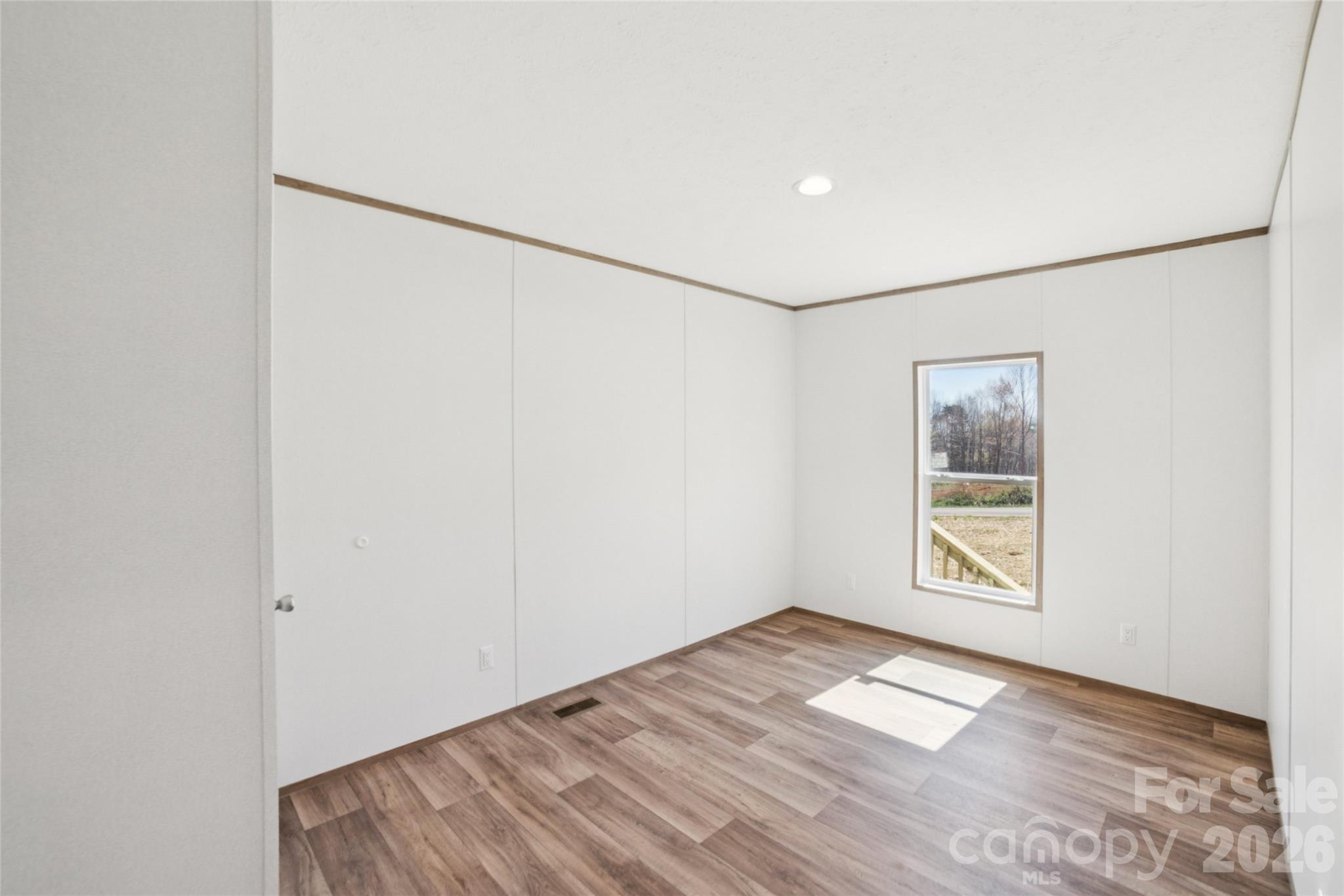 5350 Hope Road Vale, NC 28168 - Photo 11 of 24 a view of an empty room with wooden floor and a window
