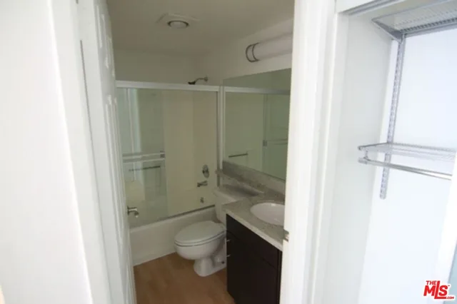 a bathroom with a granite countertop toilet a sink and a shower