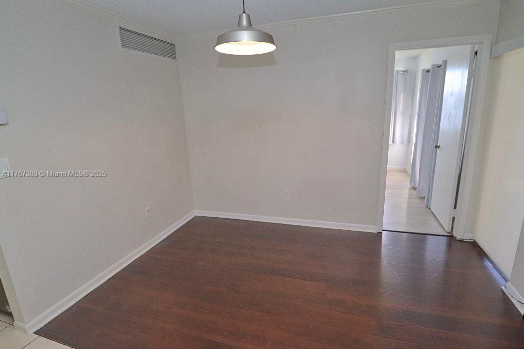 1206 North Hiatus Road, Unit 1206 Pembroke Pines, FL 33026 - Photo 6 of 18 an empty room with wooden floor and door