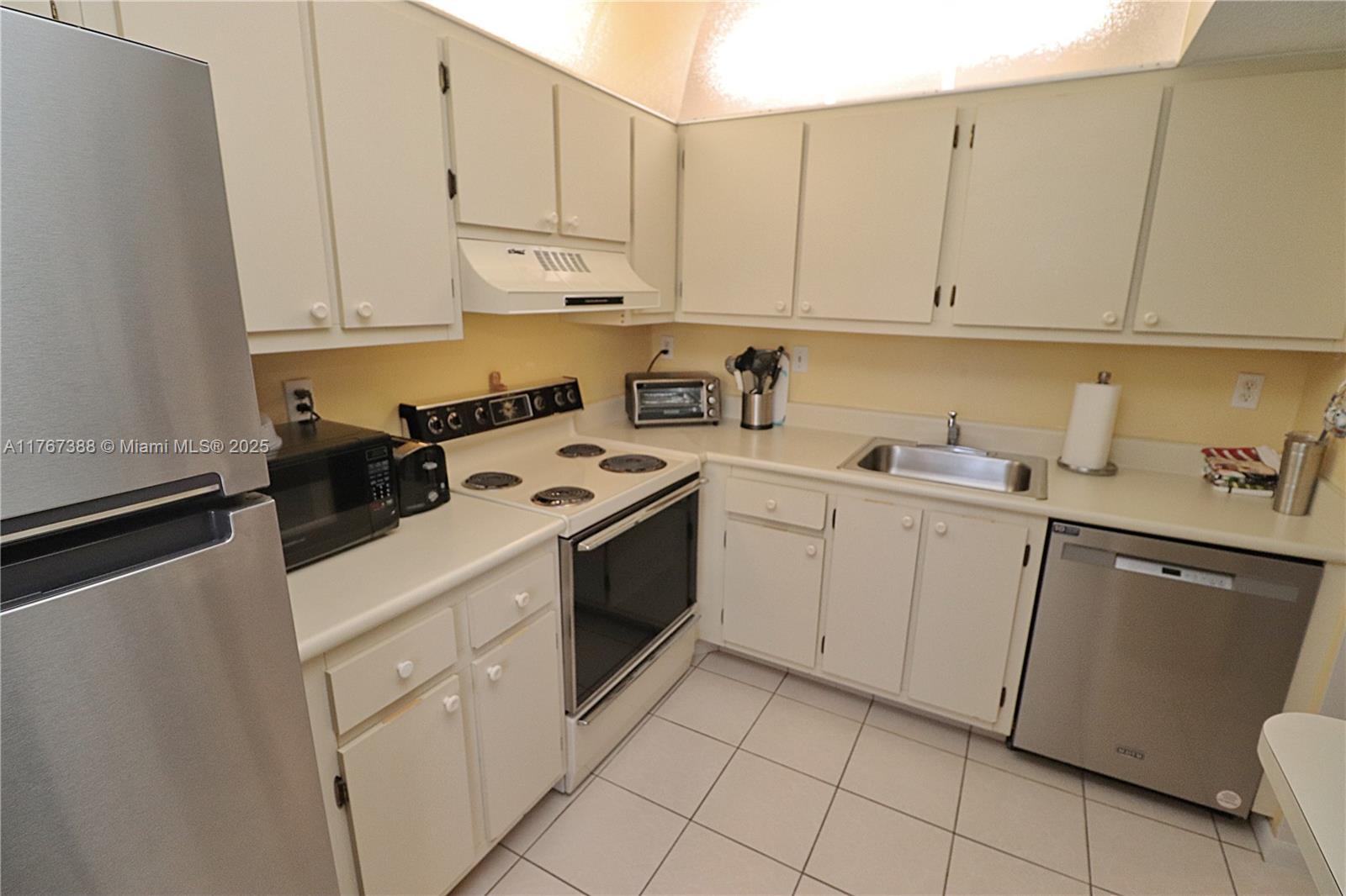 1206 North Hiatus Road, Unit 1206 Pembroke Pines, FL 33026 - Photo 7 of 18 a kitchen with cabinets appliances a sink and a counter top