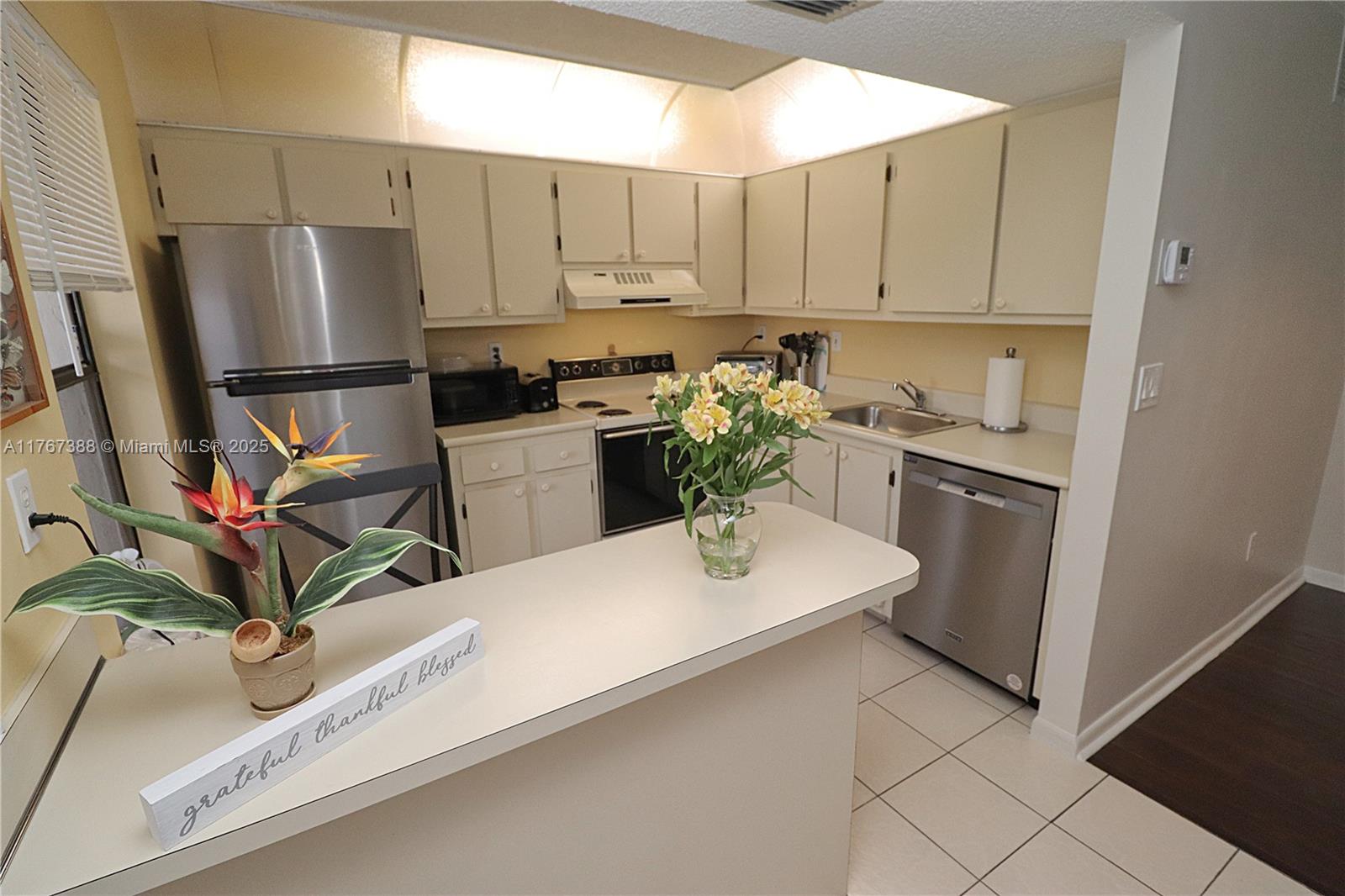 1206 North Hiatus Road, Unit 1206 Pembroke Pines, FL 33026 - Photo 8 of 18 a kitchen with cabinets and stainless steel appliances