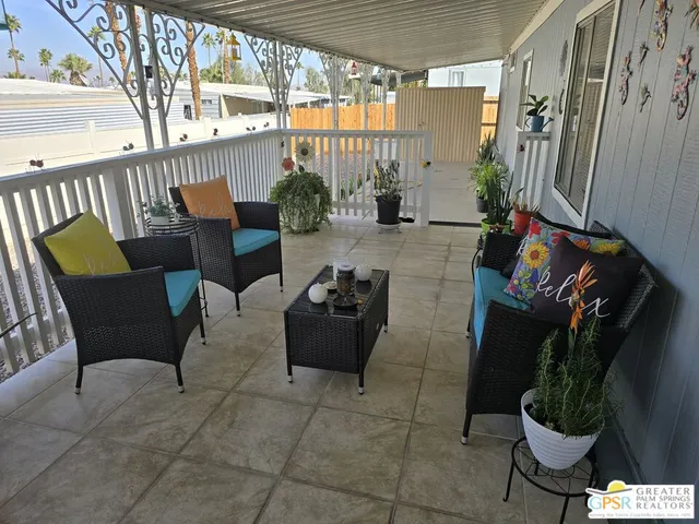 a living room with patio furniture and a potted plant