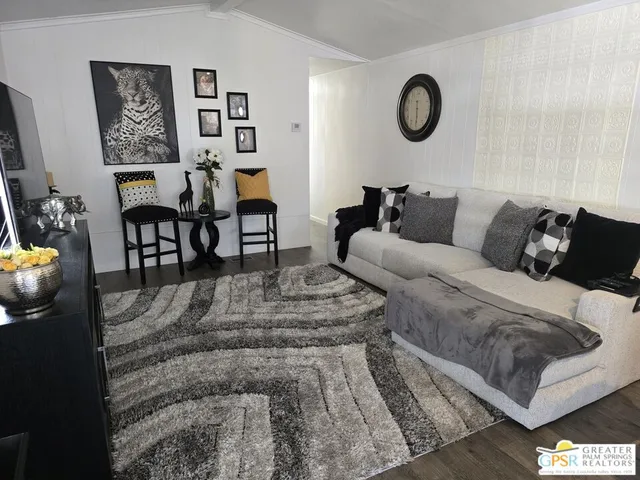 a living room with furniture wooden floor and wall paintings