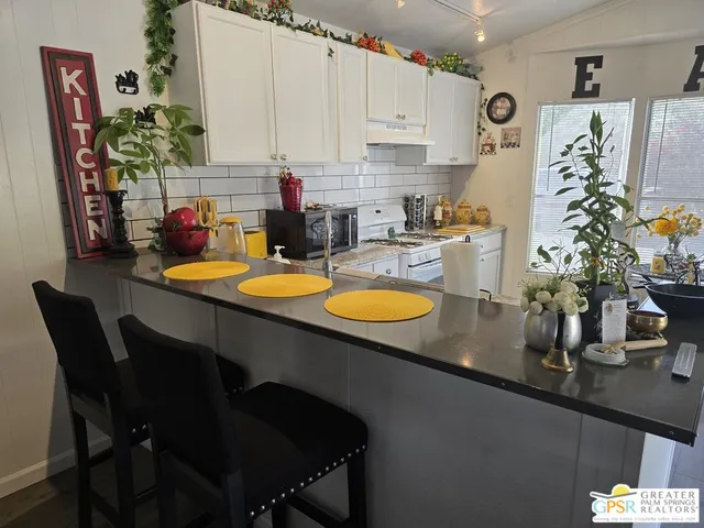 a kitchen with a table chair and white cabinets