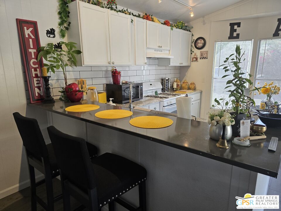 1 Running H Palm Desert, CA 92260 - Photo 5 of 22 a kitchen with a table chair and white cabinets