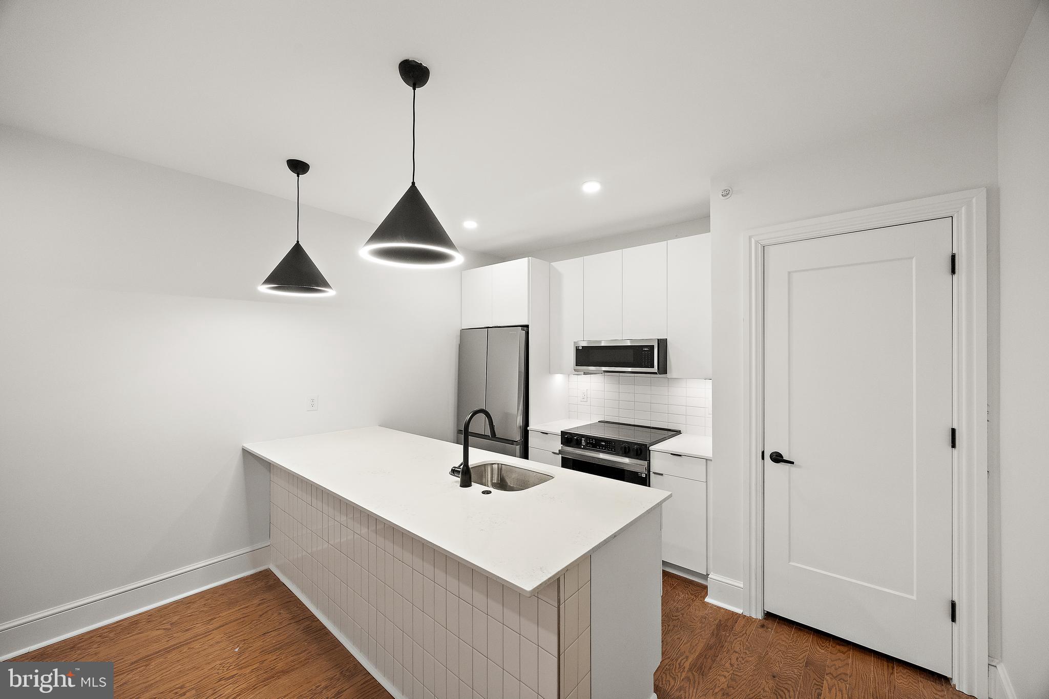 a kitchen with stainless steel appliances a stove a sink and cabinets