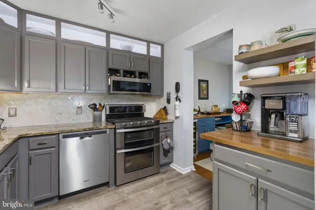 a kitchen with stainless steel appliances a stove a sink and a microwave