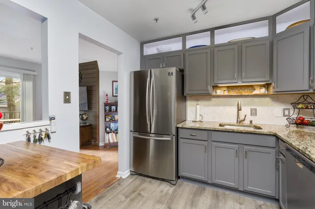 a kitchen with stainless steel appliances granite countertop a refrigerator a sink and a stove