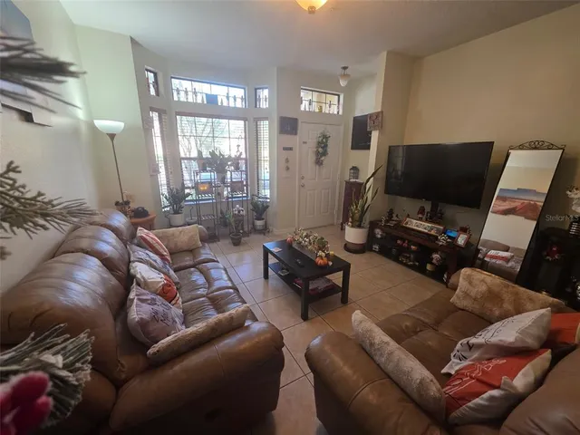 a living room with furniture a flat screen tv and a window