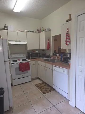 a kitchen with a sink a stove and cabinets