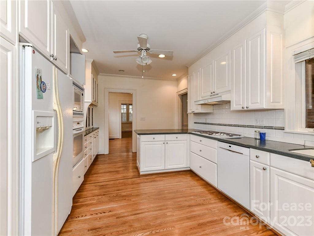 1923 Ewing Avenue Charlotte, NC 28203 - Photo 14 of 39 a large kitchen with stainless steel appliances granite countertop a lot of counter space and wooden floors