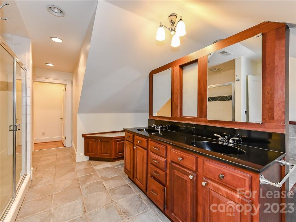 1923 Ewing Avenue Charlotte, NC 28203 - Photo 28 of 39 a bathroom with a sink a large mirror and a bathtub