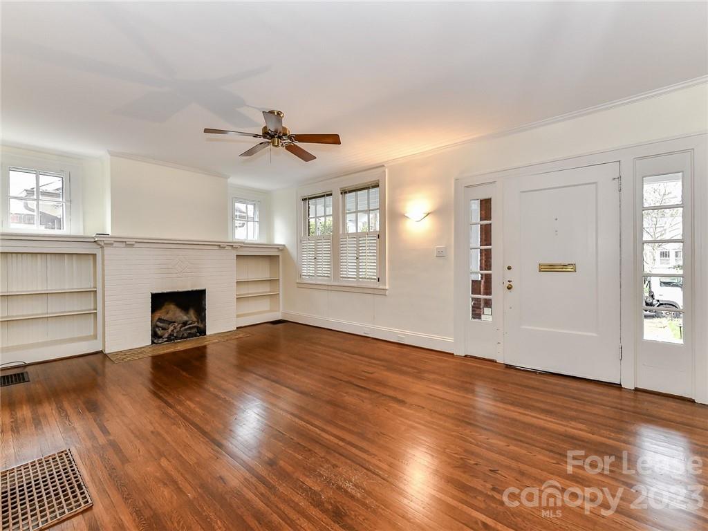 1923 Ewing Avenue Charlotte, NC 28203 - Photo 4 of 39 an empty room with wooden floor fireplace and windows