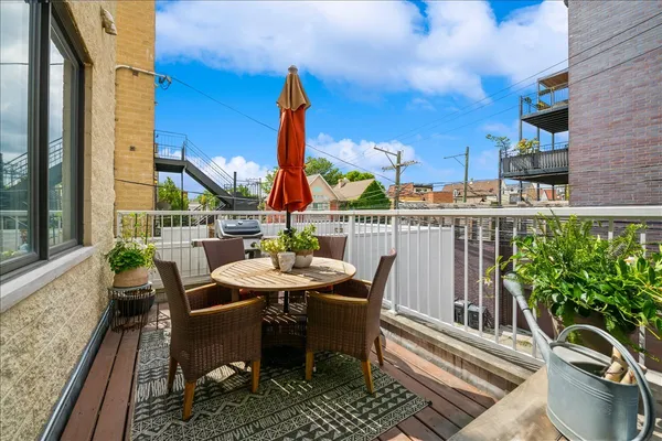 a view of a balcony with chairs and wooden floor