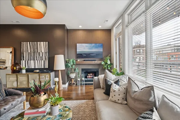a living room with fireplace furniture and a large window