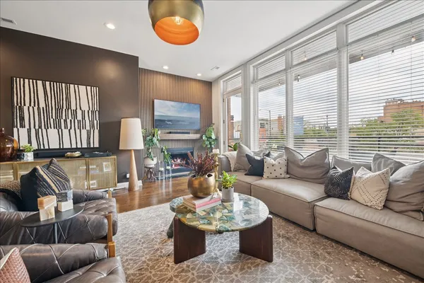 a living room with furniture a fireplace and a large window