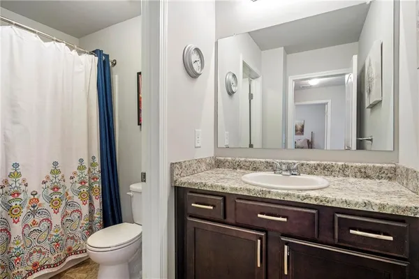 a bathroom with a granite countertop sink toilet and shower