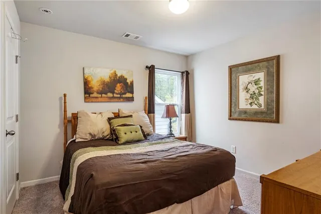 a bedroom with a bed and painting on the wall