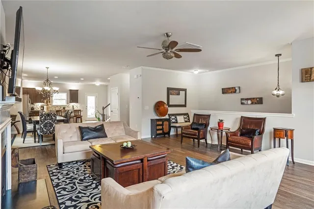 a living room with furniture kitchen view and a chandelier