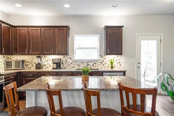 a kitchen with a table chairs sink and cabinets
