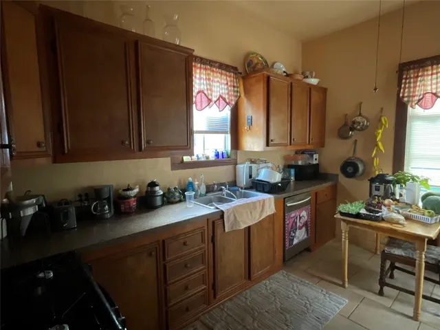 a kitchen with stainless steel appliances sink cabinets and window