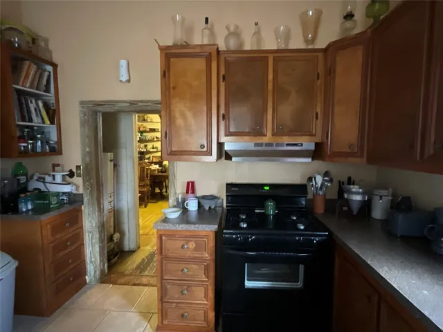 a kitchen with a refrigerator and a stove top oven