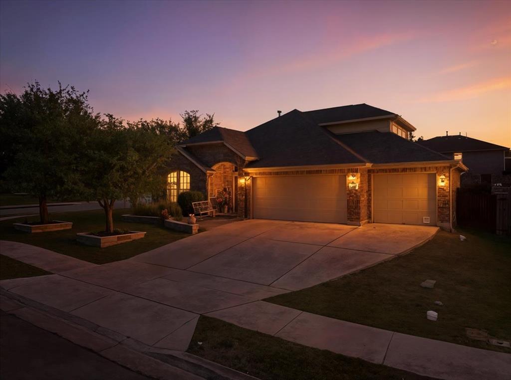 349 Razzmatazz Trail Buda, TX 78610 - Photo 2 of 27 Illuminated by dusk's glow, this inviting home features a brick facade and an attached garage.