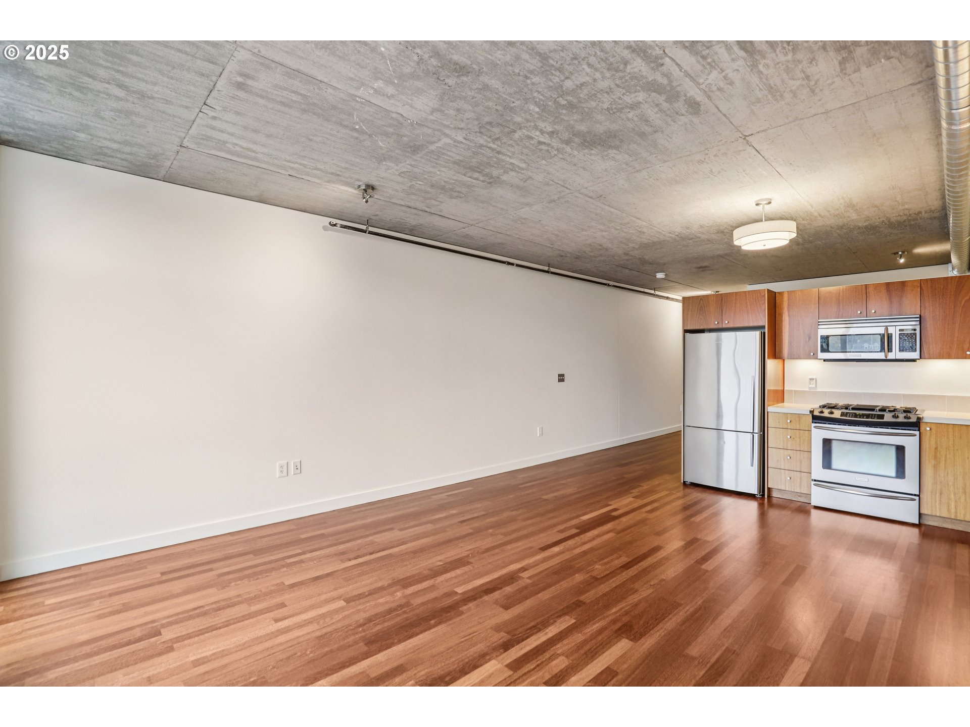 1926 West Burnside Street, Unit 906 Portland, OR 97209 - Photo 11 of 26 a view of kitchen and empty room with wooden floor
