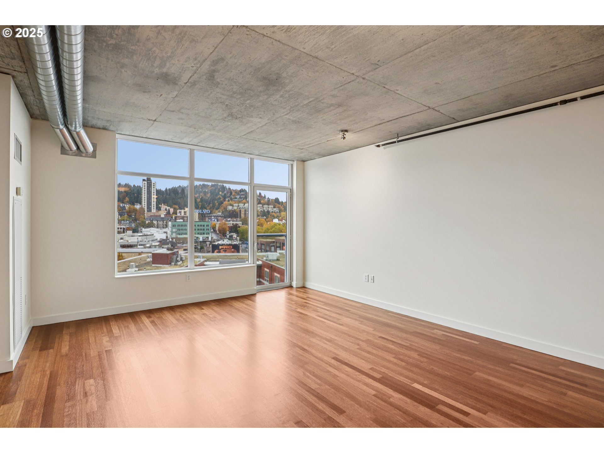 1926 West Burnside Street, Unit 906 Portland, OR 97209 - Photo 9 of 26 a view of an empty room with wooden floor and a window