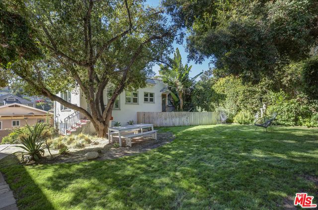 a backyard of a house with table and chairs