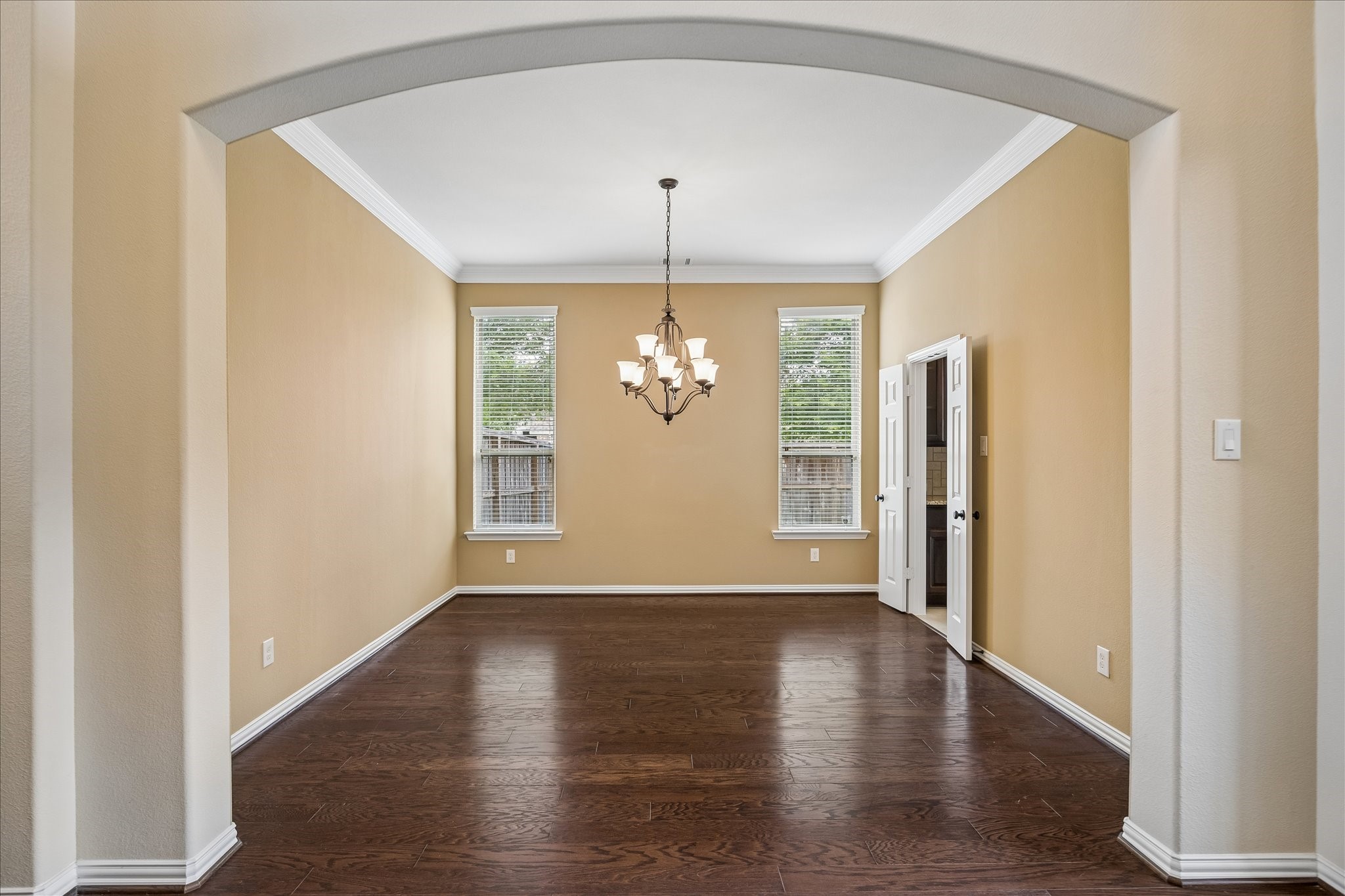 17403 Astrachan Road Richmond, TX 77407 - Photo 14 of 40 Formal dining room includes an elegant chandelier and an arched entryway, creating a welcoming and versatile space.