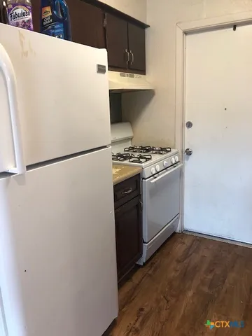 a white refrigerator freezer and a stove sitting inside of a kitchen