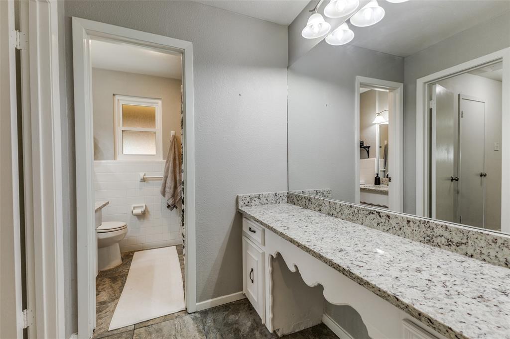 5131 Menefee Drive Dallas, TX 75227 - Photo 14 of 22 a bathroom with a granite countertop sink and a mirror