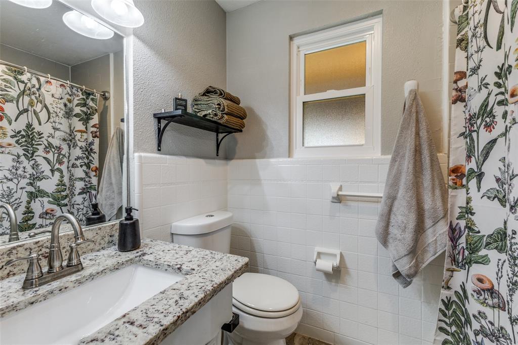 5131 Menefee Drive Dallas, TX 75227 - Photo 15 of 22 a bathroom with a sink a toilet and shower curtain