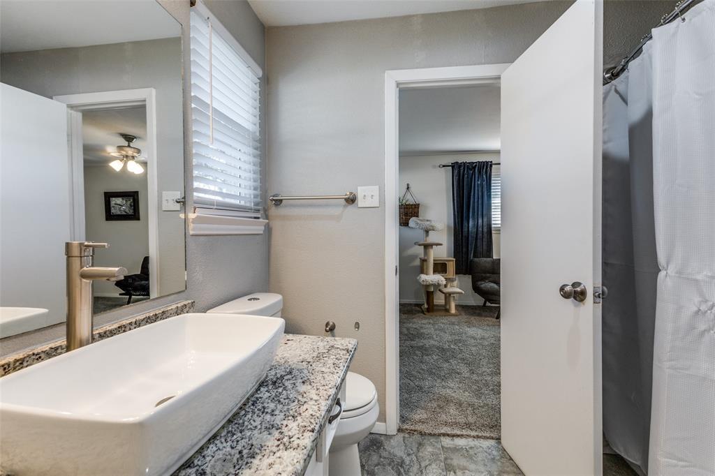 5131 Menefee Drive Dallas, TX 75227 - Photo 17 of 22 a en suite spacious bathroom with a granite countertop double vanity sink a mirror and a shower