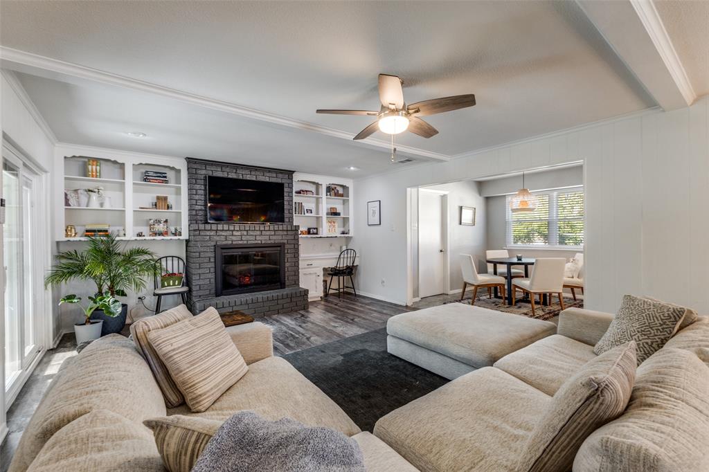 5131 Menefee Drive Dallas, TX 75227 - Photo 2 of 22 a living room with furniture a flat screen tv and a fireplace