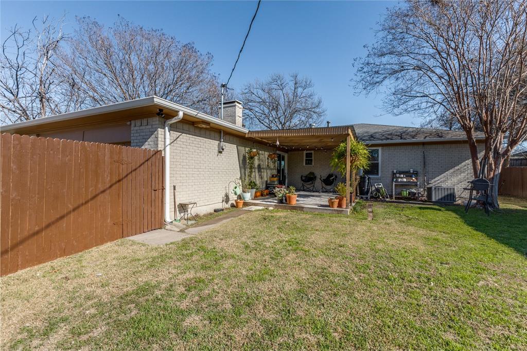 5131 Menefee Drive Dallas, TX 75227 - Photo 21 of 22 a view of a backyard with table and chairs under an umbrella