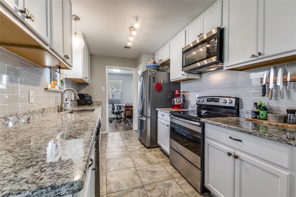 5131 Menefee Drive Dallas, TX 75227 - Photo 3 of 22 a kitchen with stainless steel appliances granite countertop a stove a sink and a microwave