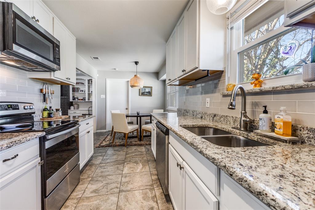 5131 Menefee Drive Dallas, TX 75227 - Photo 10 of 22 a kitchen with stainless steel appliances granite countertop a sink stove and refrigerator