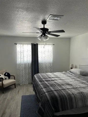 a bedroom with a bed and a ceiling fan