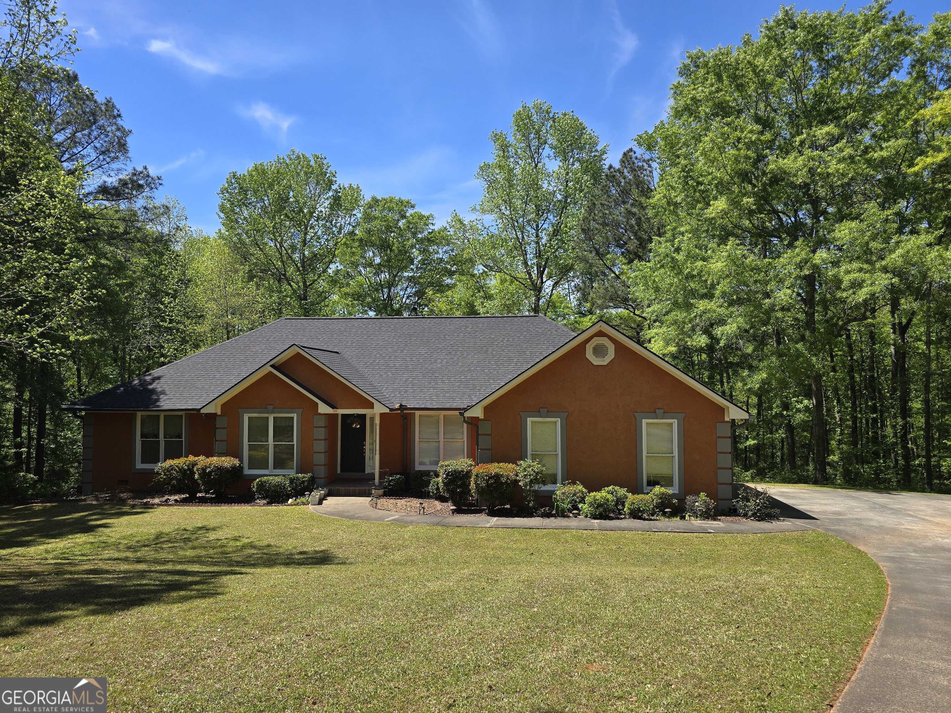 a front view of a house with a yard and trees