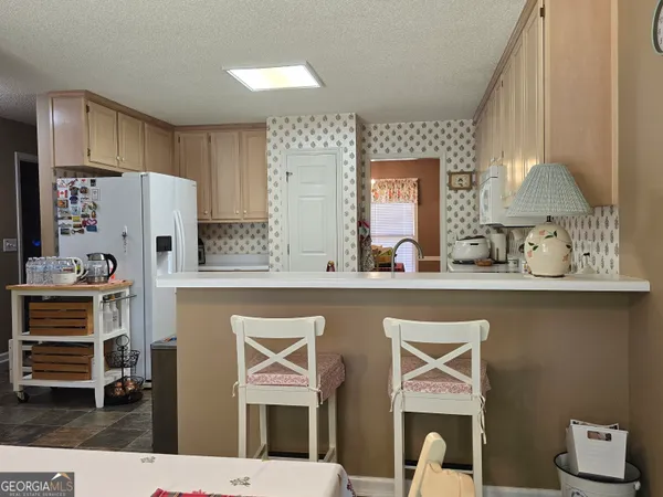 a open kitchen with stainless steel appliances granite countertop a sink and a refrigerator