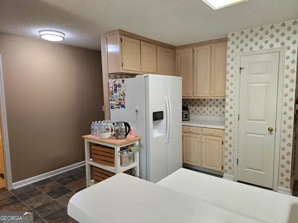 a bedroom with a bed and a refrigerator