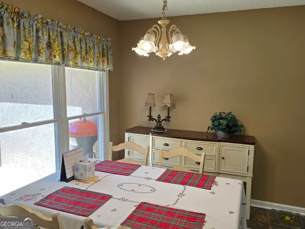 a bedroom with a bed a chandelier and dresser