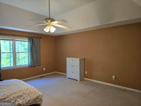 an empty room with windows and ceiling fan