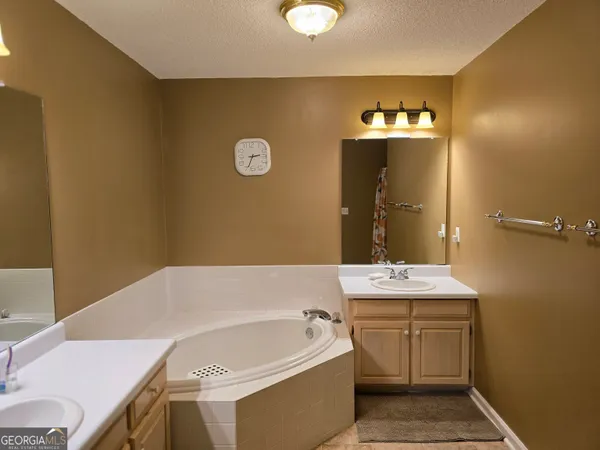 a bathroom with a bathtub sink and mirror