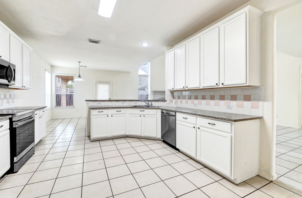 3306 Colleville Sur Mer Lane Spring, TX 77388 - Photo 15 of 40 a kitchen with a stove sink and cabinets