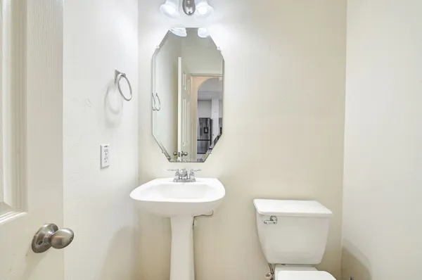 a bathroom with a toilet sink and mirror