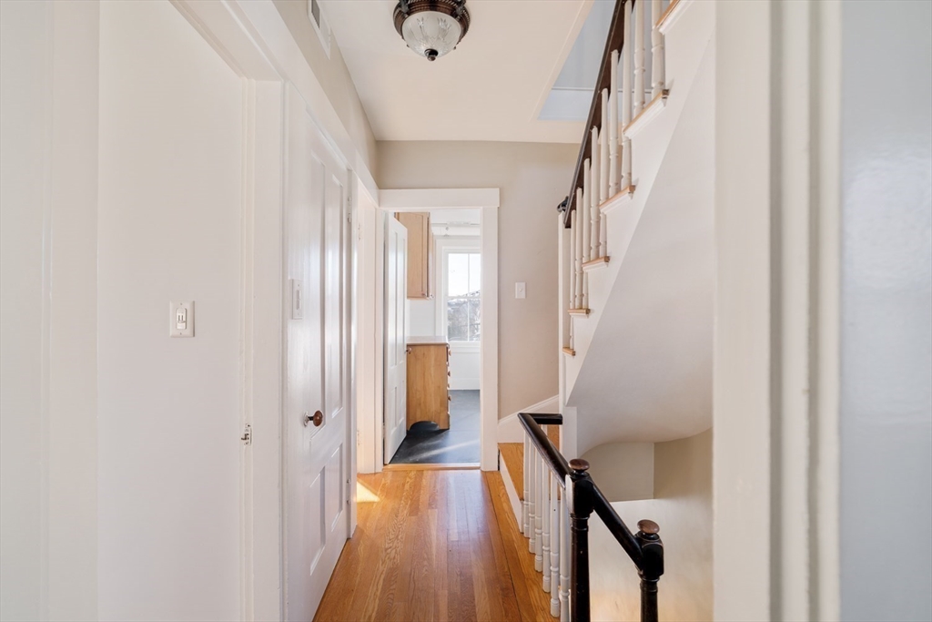 21 Berkeley Street Somerville, MA 02143 - Photo 15 of 36 a view of a hallway with wooden floor and staircase