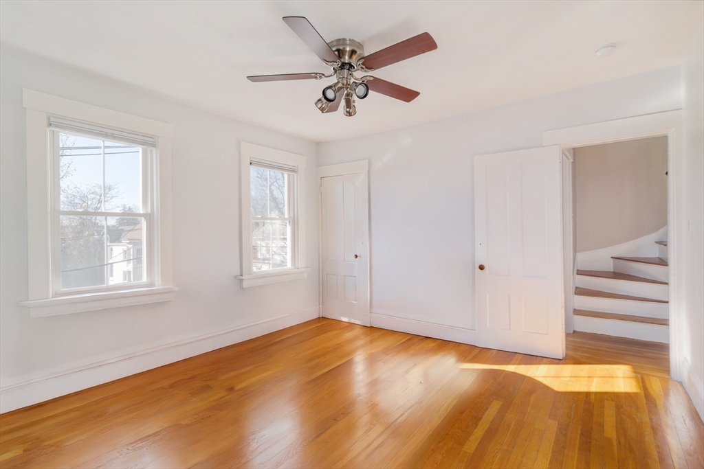 21 Berkeley Street Somerville, MA 02143 - Photo 17 of 36 a view of empty room with wooden floor and fan